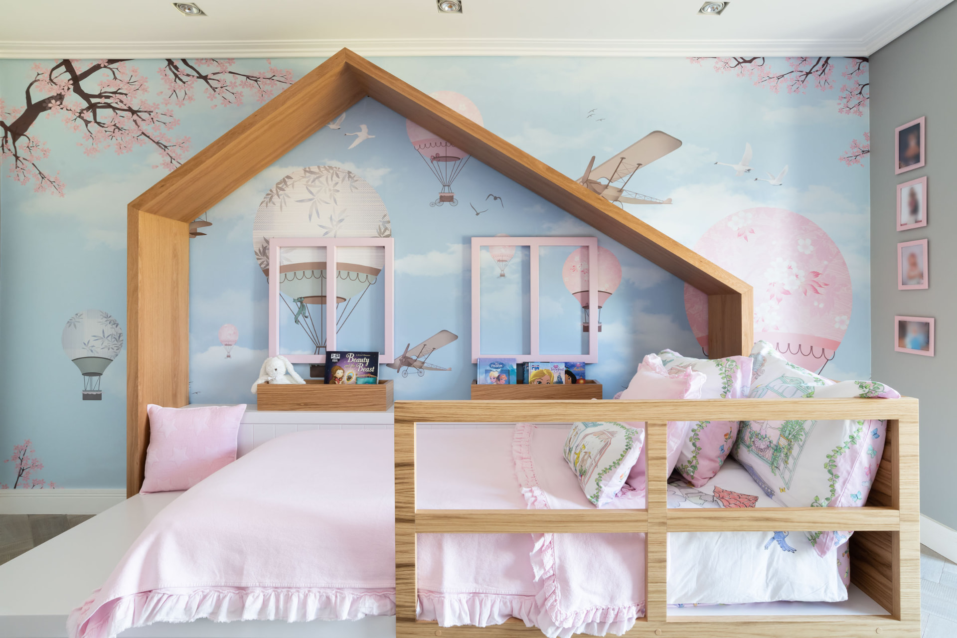 Bespoke oak house-shaped children's bed with pink bedding and blossom wallpaper