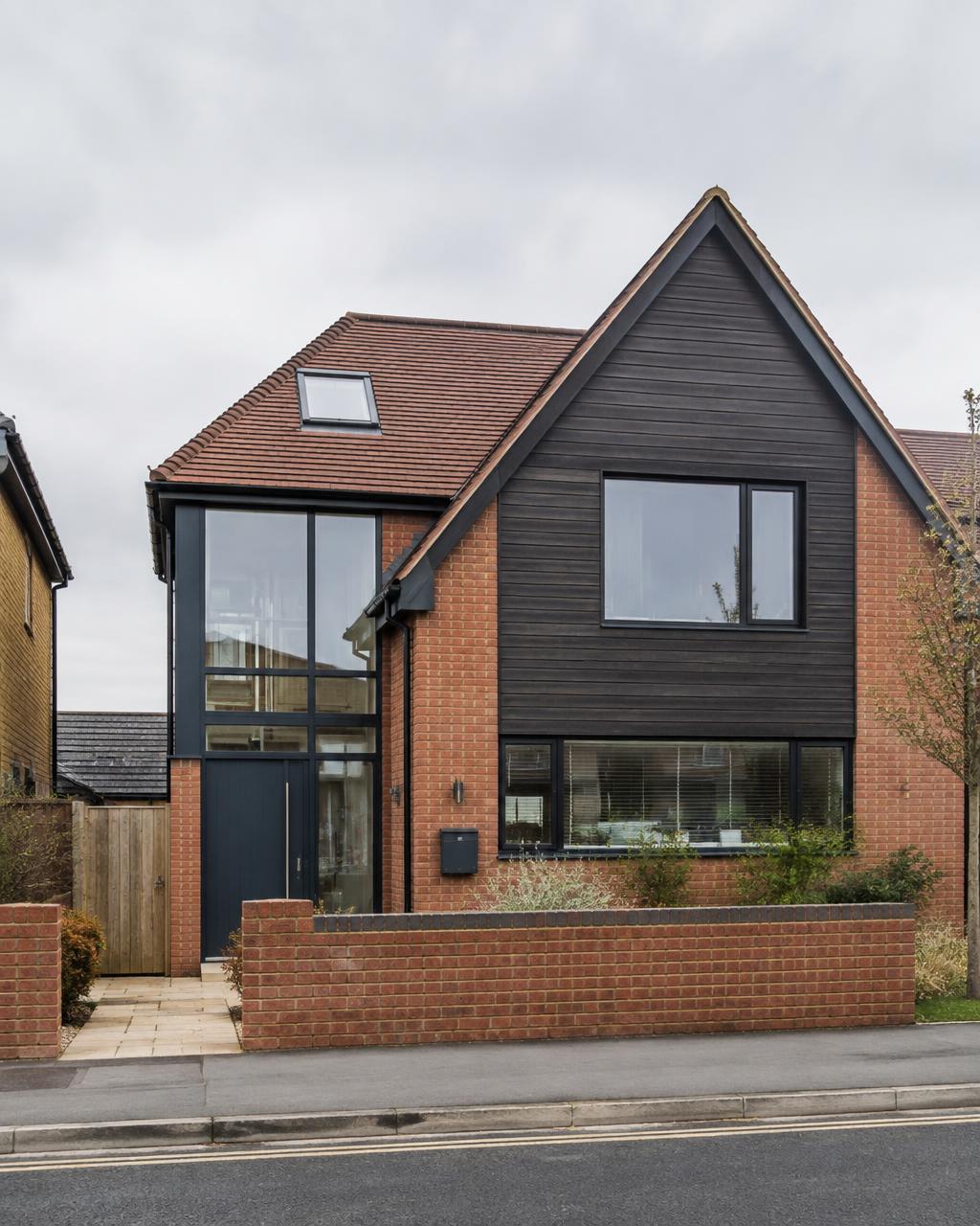 Contemporary new-build house exterior with bronze cladding at dusk